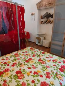 a bedroom with a bed with a floral bedspread at Mini appartamento in Livorno