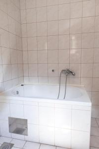 La salle de bains est pourvue d'une baignoire blanche et de carrelage blanc. dans l'établissement Apartment Sea Dance, Korcula town, à Korčula 17 autres photos