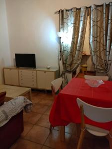 a living room with a red table and a television at Mini appartamento in Livorno