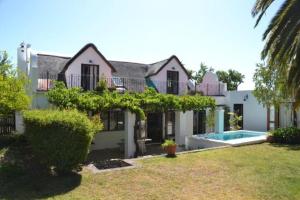 a house with a swimming pool in the yard at Petite France:luxury thatched 4BRcottage with pool in Franschhoek