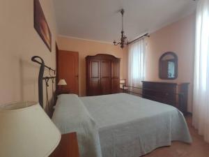 a bedroom with a bed and a dresser and a mirror at Domus de Daan in Porto Alabe