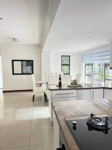 a large white kitchen with a table and a chair at Cozy home with a pool,garden and small Lapa, 2 Bed in Sandton