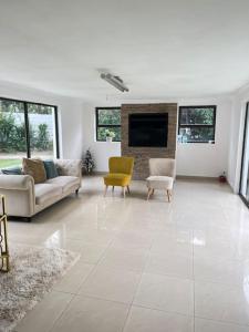 sala de estar con sofá, sillas y chimenea en Cozy home with a pool,garden and small Lapa, 2 Bed en Sandton