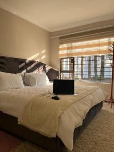 sypialnia z łóżkiem z laptopem w obiekcie Cozy home with a pool,garden and small Lapa, 2 Bed w mieście Sandton