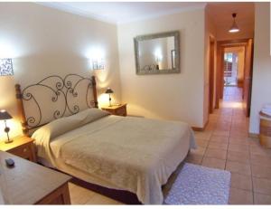 um quarto com uma cama e um espelho na parede em Citadela I, Golfe, Pool and Falesia Beach em Vilamoura