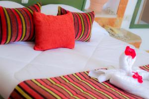 a bed with red pillows and two stuffed animals on it at Al Jazira Beach & Spa- All Inclusive - Families and Couples Only in Houmt Souk +70 photos