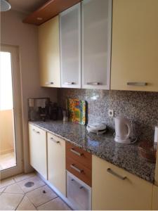 a kitchen with white cabinets and granite counter tops at Citadela I, Golfe, Pool and Falesia Beach in Vilamoura