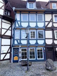 un edificio azul y blanco con una luz de la calle en la parte delantera en Ferienwohnung am Brunnenplatz, en Bad Sooden-Allendorf