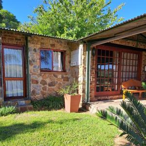 una casa in pietra con veranda e patio. di Linquenda Guest Farm a Lanseria