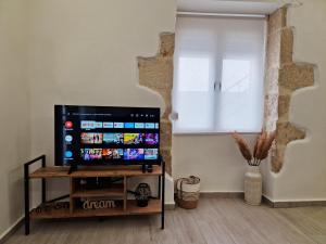 a living room with a television on a table at Granny's Nest in Kalyves