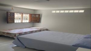 a bedroom with two beds and two windows at Bahia da Traição in Baía da Traição
