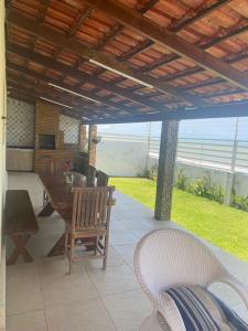 a patio with a table and chairs under a roof at Bahia da Traição in Baía da Traição