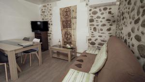 Una habitación con escritorio y una cama en una habitación en ZENSAN Meublé Maison de Village Le Boulou 66160, en Le Boulou