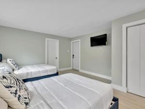 Un dormitorio con dos camas y un televisor de pantalla plana. en The Shell on Walnut Studio Hollywood Beach Free Parking, en Dania Beach
