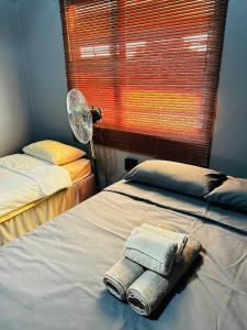 a bedroom with two beds and a fan and a window at Etosha/Omuthiya 2 Bedroom in Omuthiya