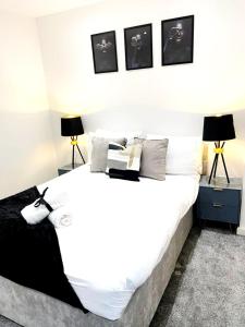a bedroom with a large bed with white sheets and pillows at 2 bed Penthouse in Liverpool City Centre in Liverpool