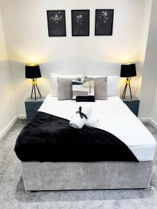 a bedroom with a large white bed with two lamps at 2 bed Penthouse in Liverpool City Centre in Liverpool