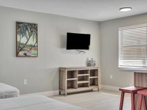 a bedroom with a tv on a white wall at The Shell on Walnut Studio with Bath Hollywood Beach Free Parking in Dania Beach
