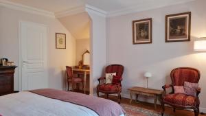 sypialnia z łóżkiem, 2 krzesłami i biurkiem w obiekcie Le Plessis BBB w mieście Blois