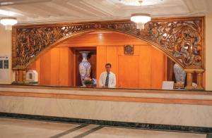 a man standing behind a counter in a lobby at Al Jazira Beach & Spa- All Inclusive - Families and Couples Only in Houmt Souk