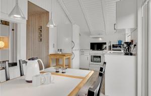 - une cuisine blanche avec une table et un réfrigérateur dans l'établissement Beautiful Home In Fan With House A Panoramic View, à Fanø