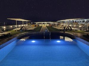 a swimming pool at night with lights on a building at Horus Eye Nile Cruse in Luxor