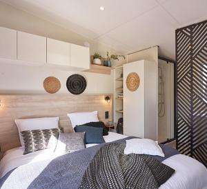 ein Schlafzimmer mit einem großen Bett in einem Zimmer in der Unterkunft Mobile home grand confort 3 chambres neuf in Saint-Raphaël