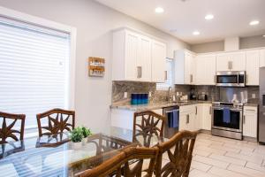 a kitchen with white cabinets and a table and chairs at Island Villa- Your Padre Island Escape in Padre Island