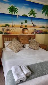 a bedroom with a bed with a painting of a beach at Caribbean Estates Montego bay 30 in Port Edward