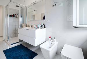 a white bathroom with a sink and a toilet at Lux 180sqm flat - entire last floor in Milan