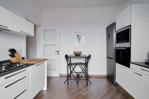 una cocina con armarios blancos y taburete. en Lux 180sqm flat - entire last floor en Milán