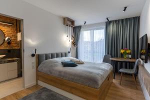 a bedroom with a bed and a desk in a room at mN apartments home - Wieliczka Town in Wieliczka