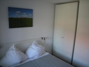 - une chambre avec un lit et 2 oreillers dans l'établissement Strandlicht, à Horumersiel