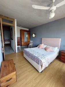 a bedroom with a large bed and a table at Cuestas Del Búho Casa Serrana in Agua de Oro