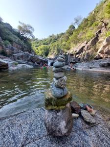 a stack of rocks sitting on top of a river at Cuestas Del Búho Casa Serrana in Agua de Oro