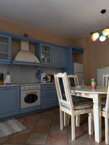 a kitchen with blue cabinets and a table with chairs at Blue House in Kóronos