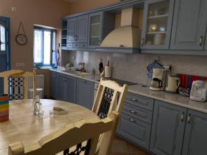 a kitchen with blue cabinets and a wooden table at Blue House in Kóronos