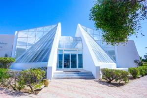 a large white building with stairs in front of it at Al Jazira Beach & Spa- All Inclusive - Families and Couples Only in Houmt Souk