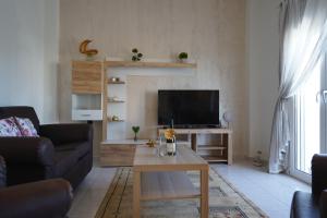 a living room with a couch and a tv at Kyriakos Apartment in Mastichari
