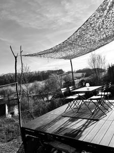 two chairs and a table on a wooden deck at The Grey Tiny in Chimay