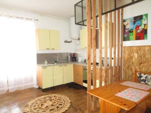 a kitchen with white cabinets and a wooden table at Appartement Rez de chaussée Résidence les Oliviers in Langeac