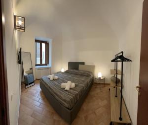 IN MEDIA URBE - intero appartamento في لاكويلا: غرفة نوم عليها سرير وفوط بيضاء