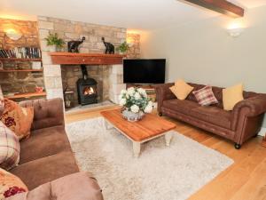a living room with couches and a fireplace at The Steadings in Morpeth