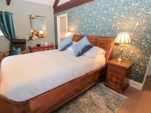 a bedroom with a bed and a lamp and a chair at The Steadings in Morpeth
