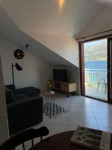 un salon avec un canapé et une télévision et un balcon dans l'établissement Apartment Sea Dance, Korcula town, à Korčula