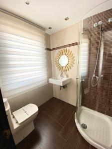 een badkamer met een toilet, een wastafel en een douche bij Villa OLYMPIA in Castro-Urdiales