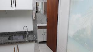 a bathroom with a sink and a mirror at Kitinet Container próximo Praia e Beto Carrero in Penha +32 photos
