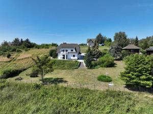 a house on top of a hill with a yard at Victoria's Village Sauna & Jacuzzi in Kołczewo