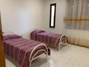 Duas camas num quarto com uma janela em Casetta Genneria em Seùlo