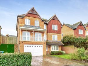 a large brick house with a white garage at Carey in Eastchurch